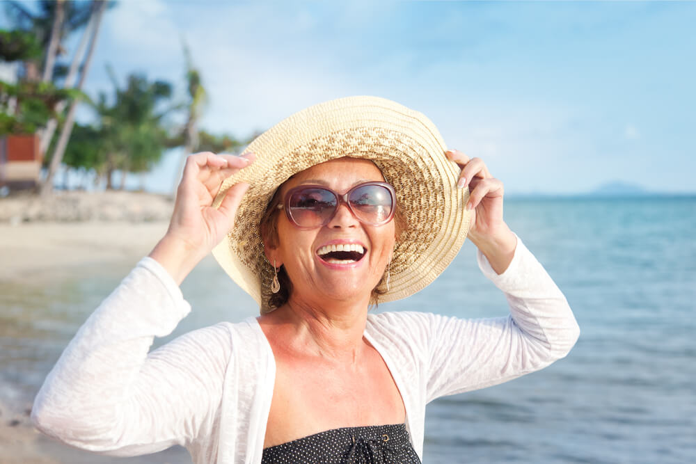 Happy mature woman enjoying on the beach